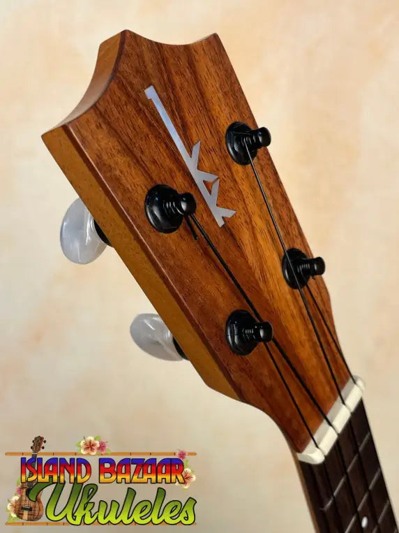 Wooden headstock of Kamaka Soprano Ukulele HF-1 with decorative arrow and tuning pegs
