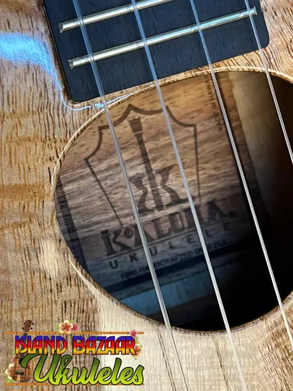 Wooden ukulele with visible strings and Kala logo inside KoAloha KTM-00 Mango Tenor Ukulele