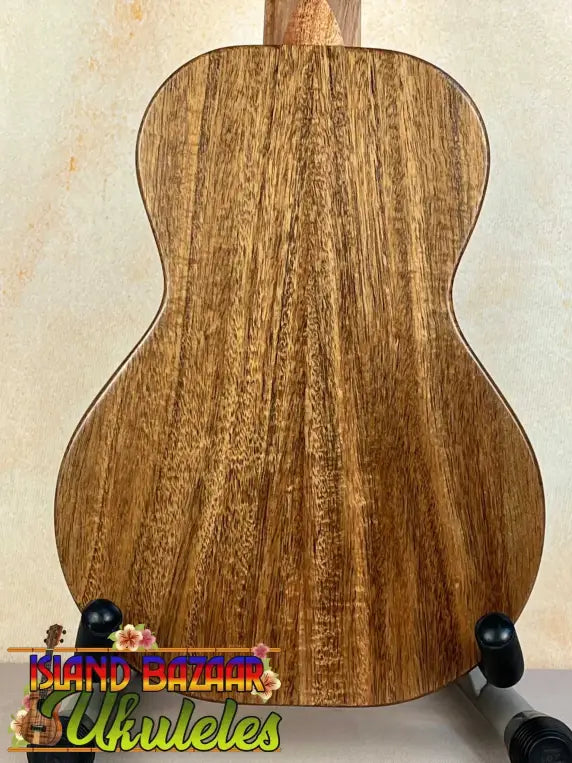 Wooden acoustic guitar back panel on black stand for KoAloha Opio Concert Ukulele