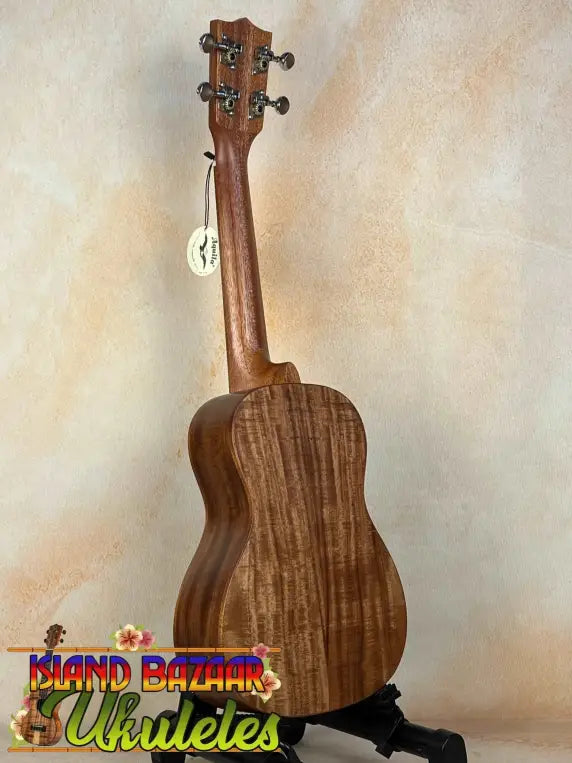 Wooden Concert Acacia Ukulele showcasing wood grain on a stand in a beginners bundle
