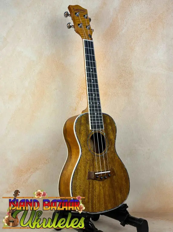 Wooden Concert Mango Ukulele with rich brown finish on black stand for beginners