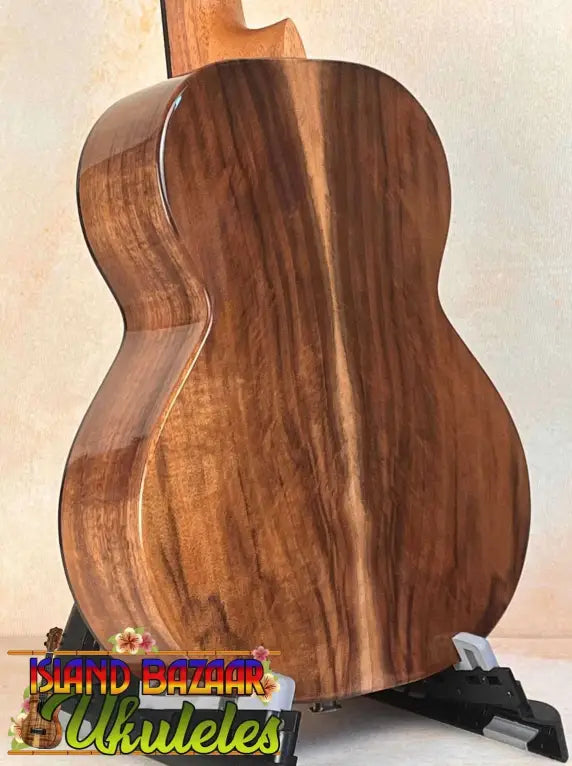 Electro-Acoustic Flight Voyager Tenor Ukulele with walnut wood grain back on stand