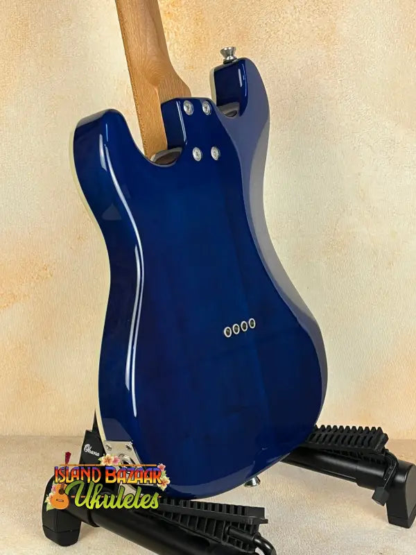Glossy blue electric guitar on black stand, Flight Pathfinder Tenor Electric Ukulele