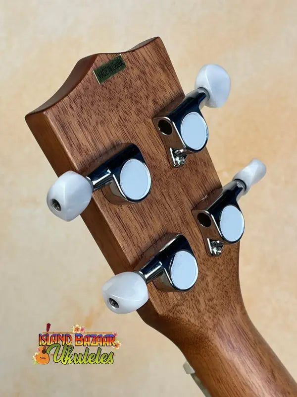 Wooden headstock of Kala Archtop Tenor Ukulele with white tuning pegs, classic archtop design