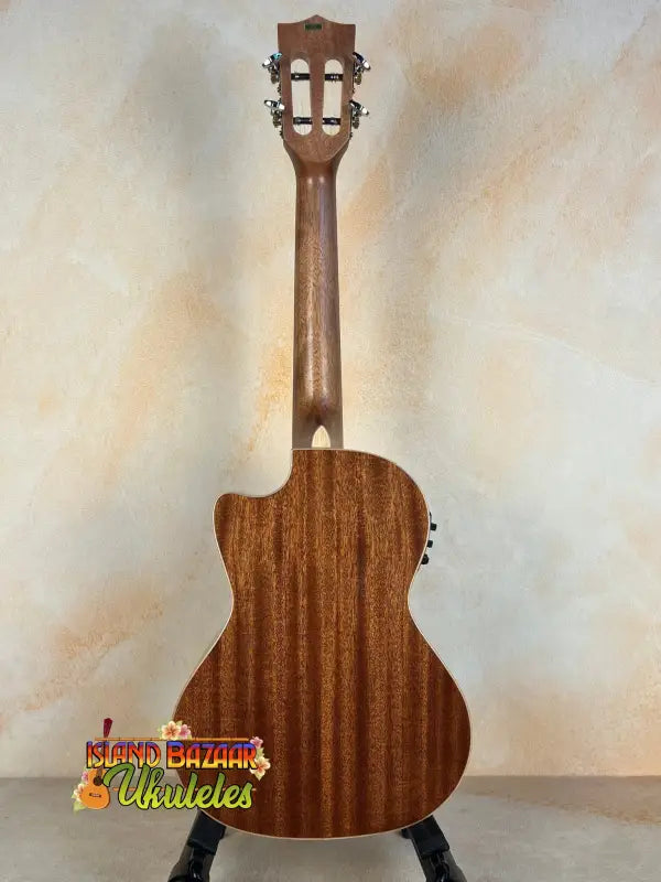 Wooden acoustic guitar on black stand showcasing Kala KA-SMH-TG-CE Tenor Electric Ukulele