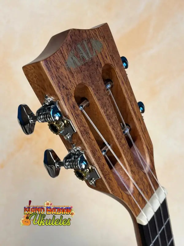 Wooden headstock of Kala KA-SMH-TG Solid Mahogany Tenor Ukulele with black tuning pegs