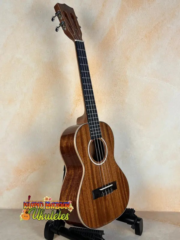 Kala KA-SMH-TG Solid Mahogany Tenor Ukulele with dark grain and white trim on stand