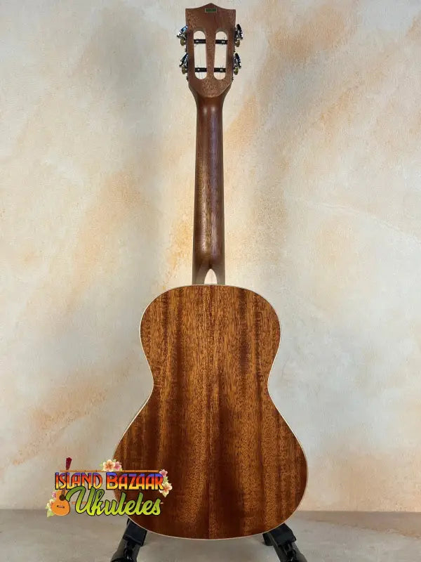 Classical acoustic guitar with a rich brown body alongside Kala KA-SMH-TG ukulele