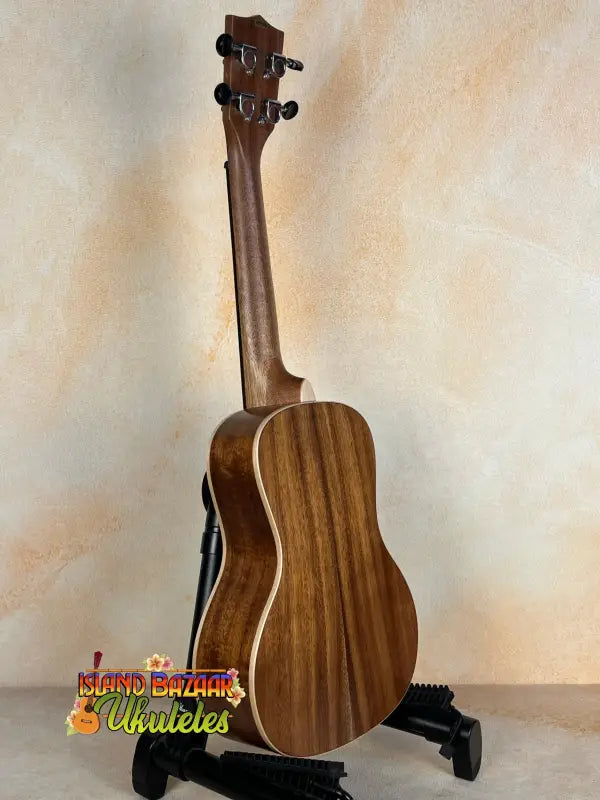 Wooden Kala SA-C Concert Ukulele on black stand, showcasing spruce & acacia design