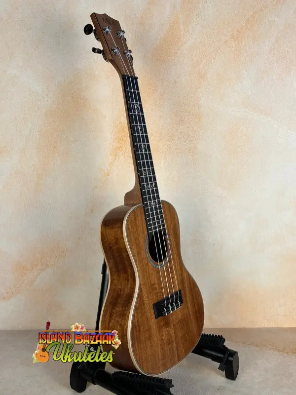 Wooden Kala SA-C Concert Ukulele on a black stand, showcasing Spruce & Acacia design