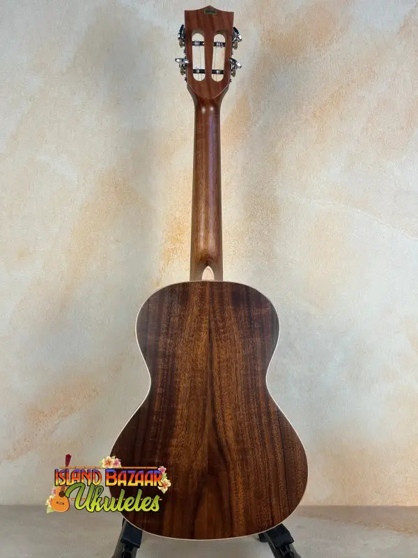 Classical acoustic guitar with dark wood finish near Kala SA-T Tenor Ukulele display