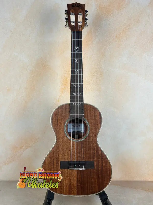 Wooden Kala SA-T Tenor Ukulele with dark brown finish and black strings at Island Bazaar Ukes