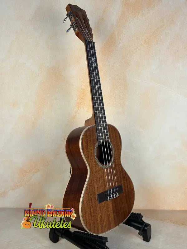 Wooden baritone ukulele on stand, highlighting Kala SA-T Tenor Ukulele’s design and tone