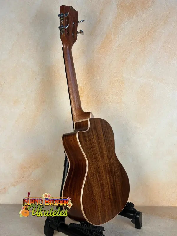 Wooden acoustic guitar with dark brown finish on black stand for Kala SA-TE-C Tenor Electric