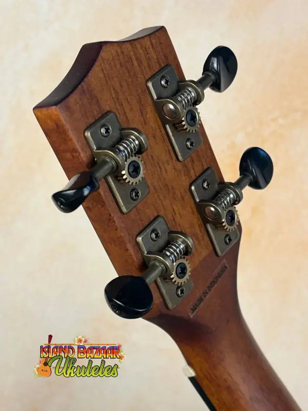 Guitar headstock with black tuning pegs on Kala Satin Hawaiian Koa Tenor Electric Ukulele