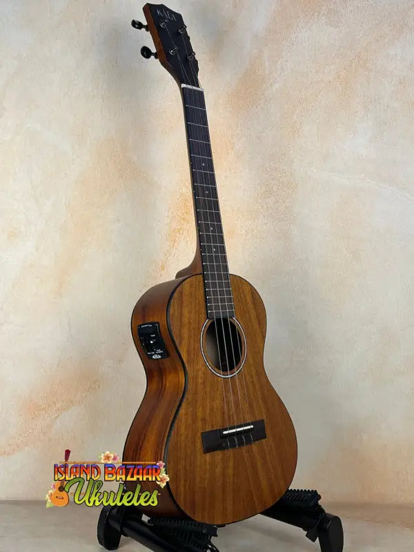 Kala Satin Hawaiian Koa Tenor Electric Ukulele with EQ on a black stand