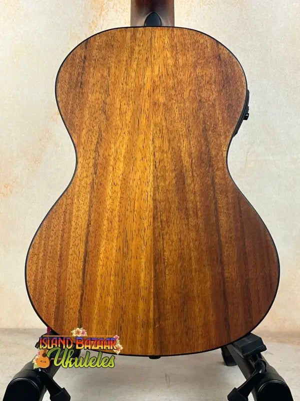 Wooden acoustic guitar showcasing Kala Satin Hawaiian Koa Tenor Electric with rich finish