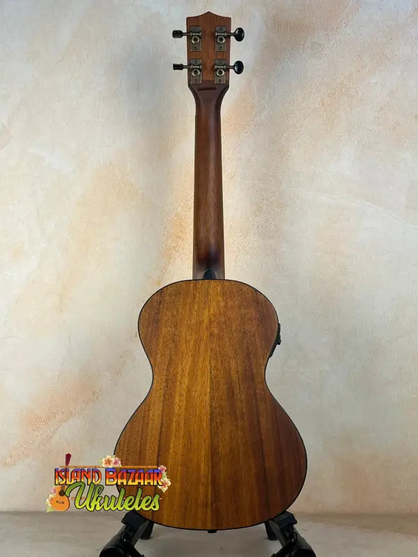 Kala Satin Hawaiian Koa Tenor Electric Ukulele with EQ on black stand, natural finish