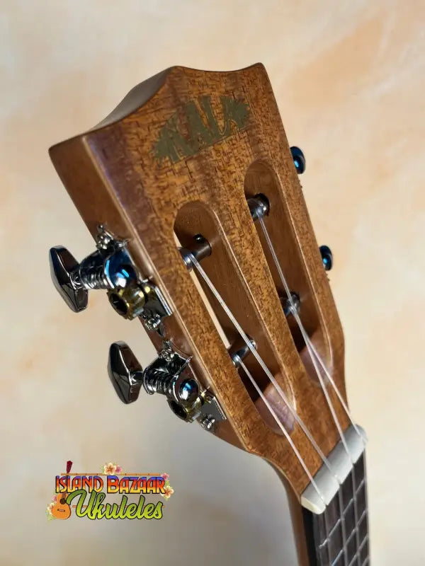 Wooden headstock of Kala SMH-CG Concert Ukulele with decorative patterns and black tuning pegs