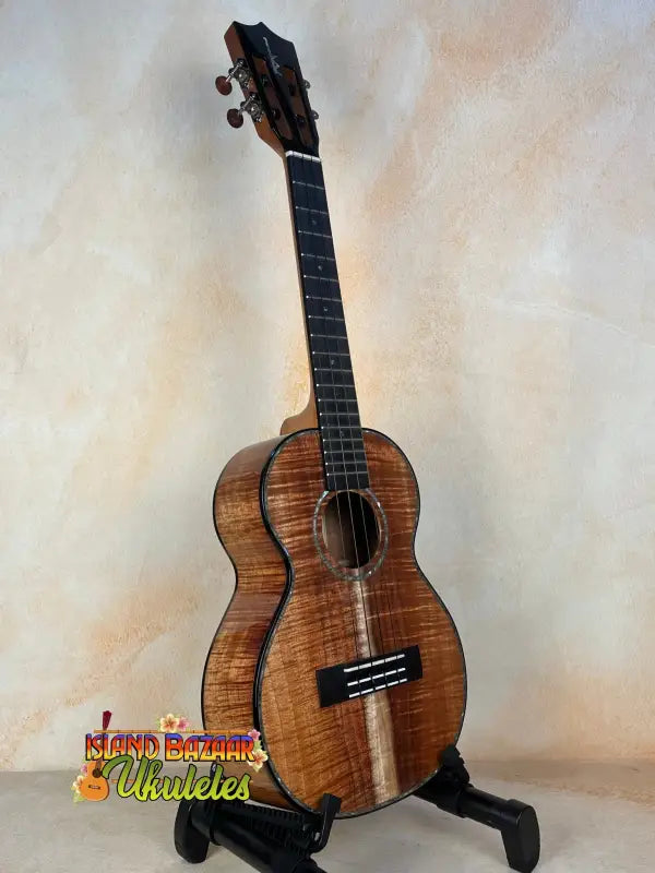 Wooden Kamaka HF3-D2i Tenor Uke with unique grain, displayed on black stand