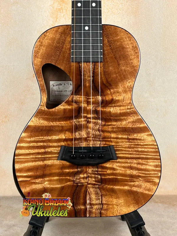 Brown wooden Kanile’a DK-T Pro Tenor Ukulele with D-hole design and premium koa finish