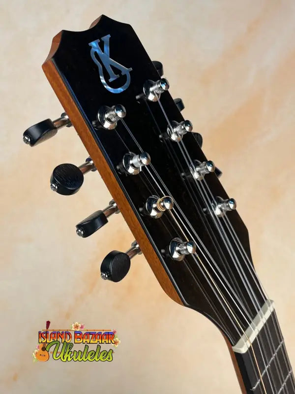 Guitar headstock with chrome tuning pegs and blue logo on Kanile’a Eight String Ukulele