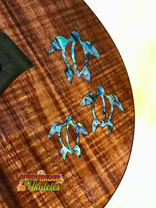 Three turquoise sea turtle designs on curly koa wood for Kanile’a HNS-T-PREM Concert Ukulele
