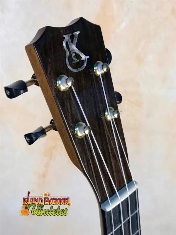 Black guitar headstock with silver pegs for Kanile’a HNS-T-PREM Concert Ukulele, curly koa