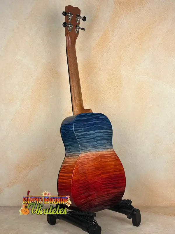 Blue and red Kanileʻa ʻILIKAI T Pro Tenor Ukulele on stand, perfect for island bazaar shoppers