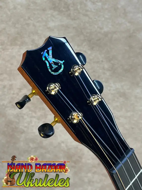 Black tenor ukulele headstock with iridescent inlay and gold tuning pegs from kanileʻa kpa pro premium solid mango