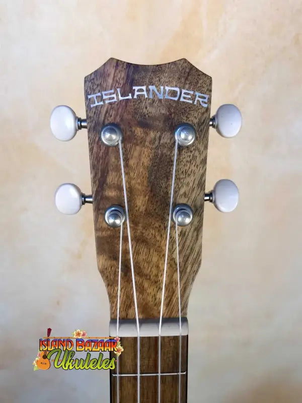 Wooden ukulele headstock showcasing Islander branding and white tuning pegs for rich tones