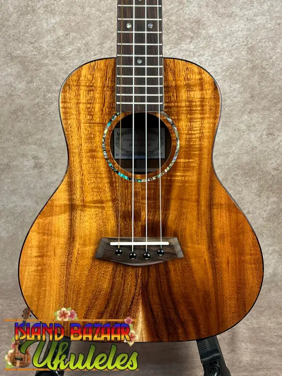 Premium koa ukulele with figured wood body, abalone rosette, and dark fretboard