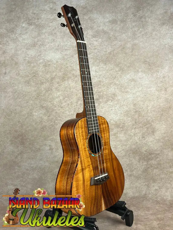 Glossy brown Kanile’a Super Tenor Koa Ukulele with black tuning pegs and bridge