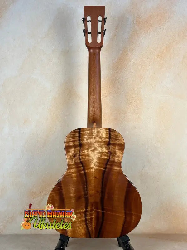 Wooden acoustic guitar showcasing natural grain in Kanile’a Super Tenor D-Hole Premium Koa Ukulele