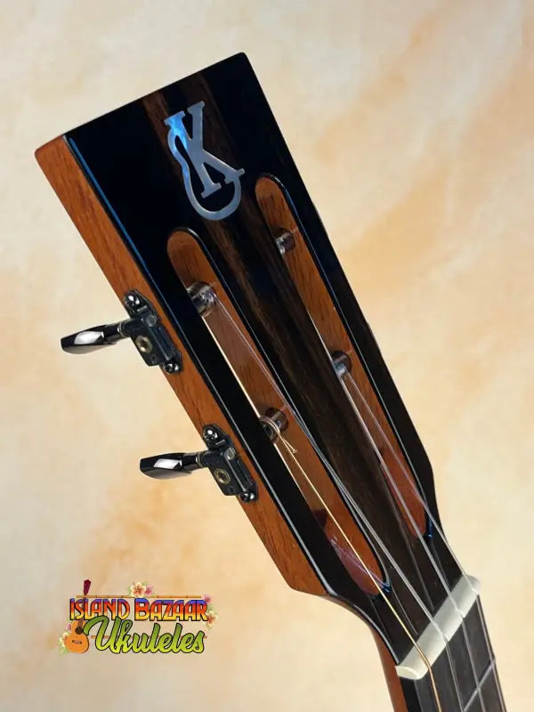 Guitar headstock with wooden trim and chrome tuning pegs of Kanile’a Super Tenor Ukulele