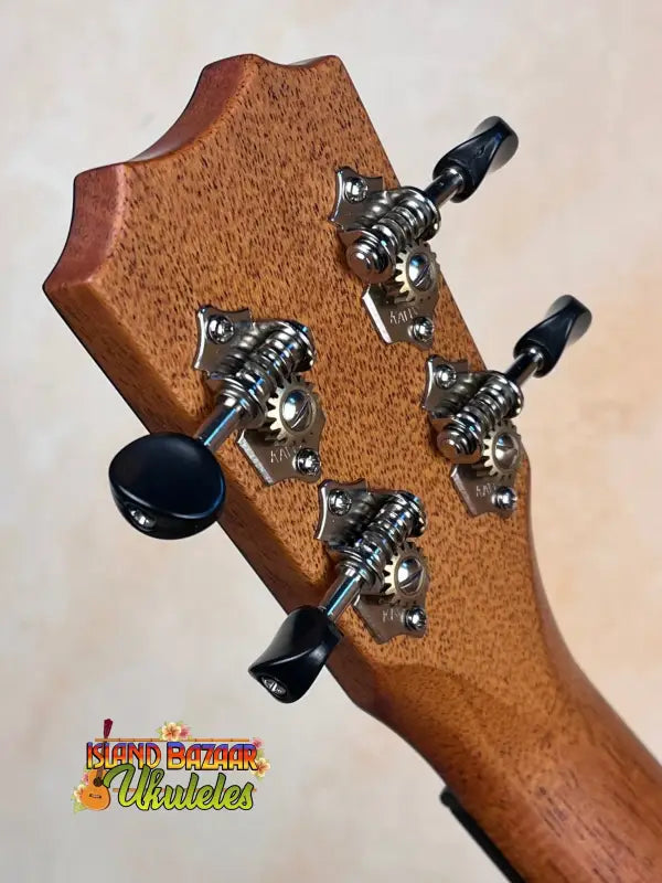 Guitar headstock with black tuning pegs and chrome hardware on Kanile’a Super Tenor Ukulele