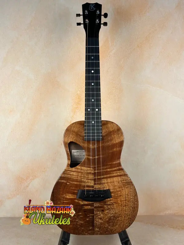 Brown wooden ukulele by Kanile’a Tenor D-1 featuring solid Hawaiian Koa in deluxe gig bag