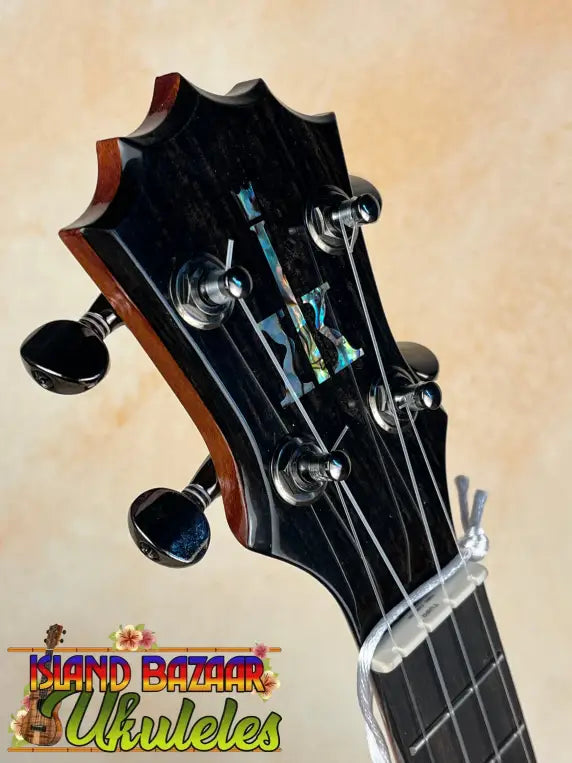 Guitar headstock of KoAloha Concert Hawaiian Ukulele with black tuning pegs and inlaid design