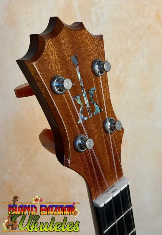 Guitar headstock with decorative inlay and tuning pegs on KoAloha KCM-00 Concert Ukulele