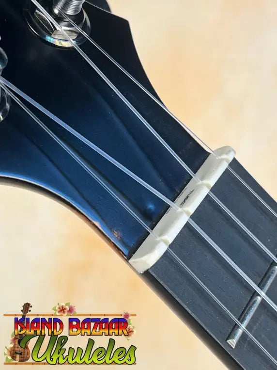 Guitar neck with a capo on KoAloha KCM-10RP Royal Pikake Satin-Finish Solid Hawaiian Koa