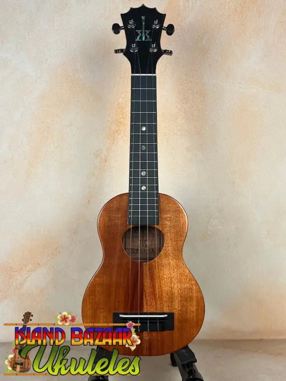 Wooden soprano ukulele with black headstock on stand, showcasing KoAloha KSM-00 design