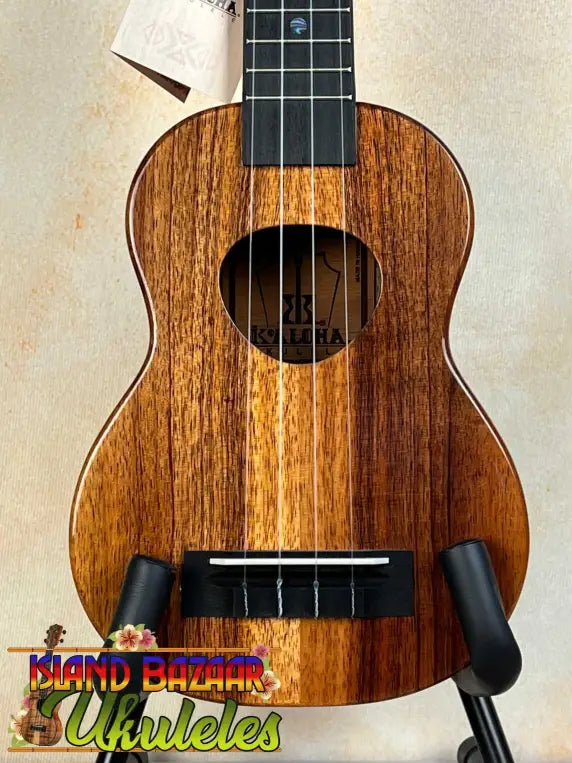 Wooden KoAloha KSM-00 Soprano Ukulele with Hawaiian Koa and Ebony Fretboard on stand