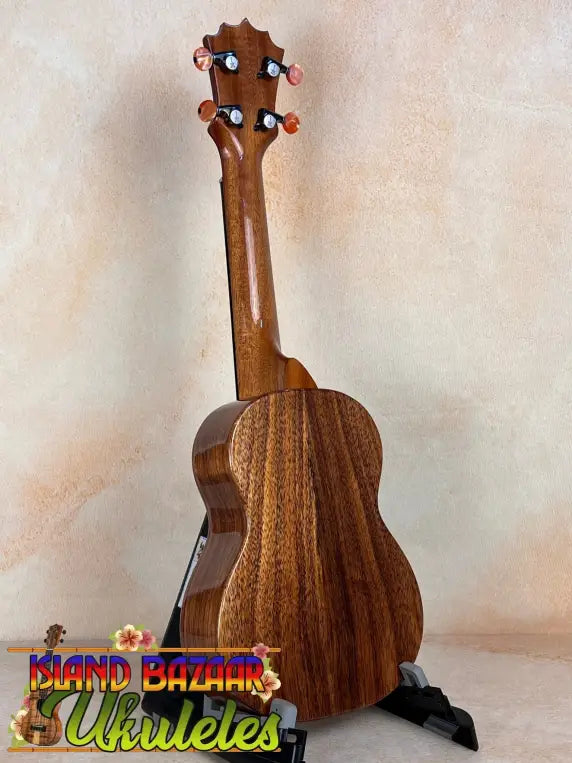 Wooden KoAloha KSM-10 Soprano Ukulele with striped grain on black stand, Pikake Satin Finish