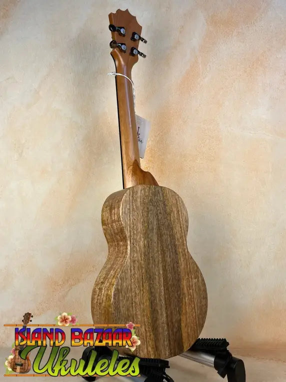 Wooden KoAloha KTM-10RP-MG Tenor Mango Ukulele with dark grain on a stand