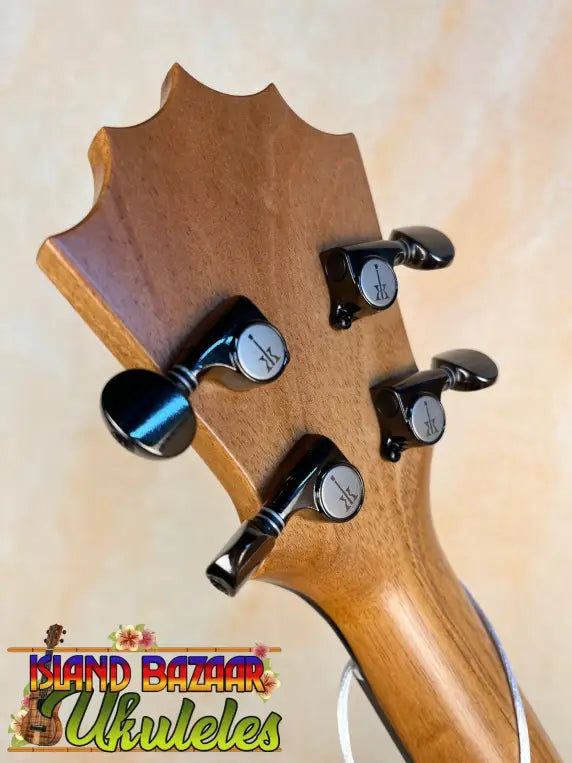 Wooden guitar headstock with black tuning pegs on KoAloha KTM-10RP-MG Tenor Mango Ukulele
