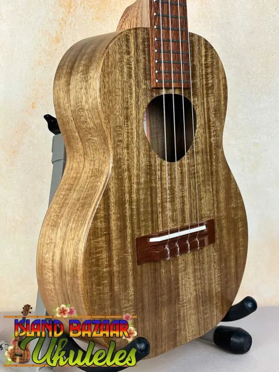 Wooden KoAloha KTO-10 Opio Tenor Ukulele with natural grain finish on black stand
