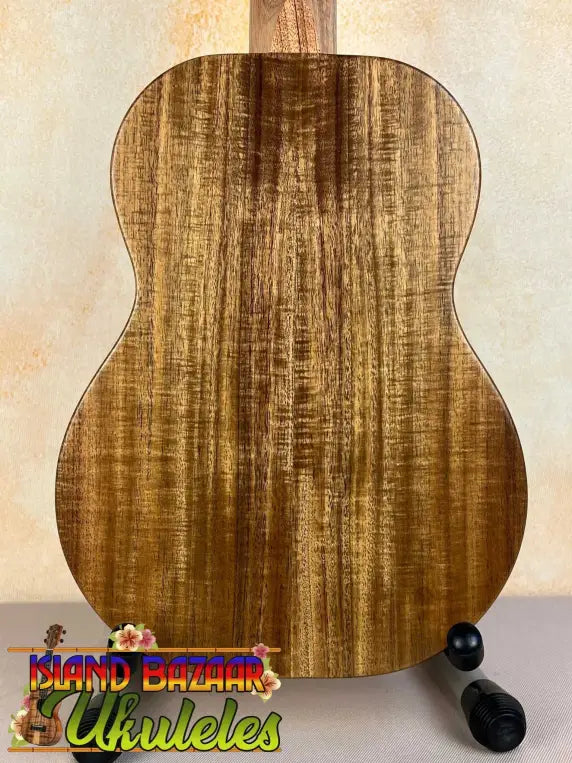 KoAloha KTO-10 Opio Tenor Ukulele with striped wood grain pattern on a black stand