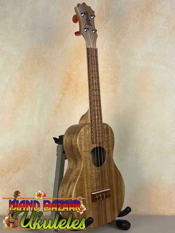 Wooden KoAloha Opio Concert Ukulele made of Koa and Mango on a black stand