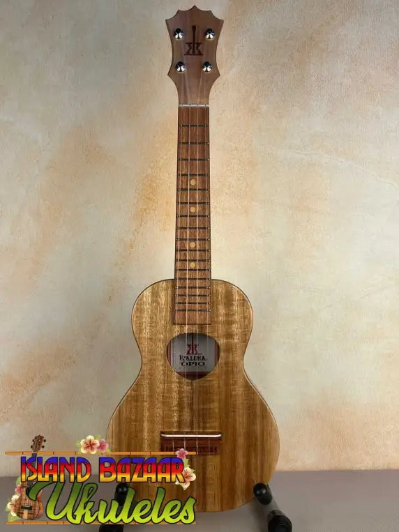 Wooden KoAloha Opio Concert Ukulele showcasing natural grain patterns and gig bag