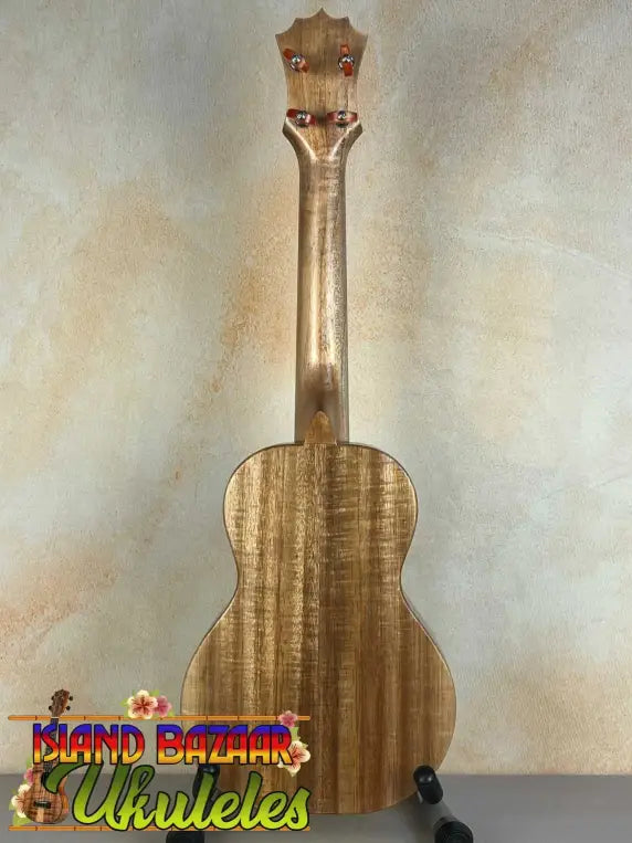 Wooden KoAloha Opio Concert Ukulele in Koa and Mango woods displayed on a stand
